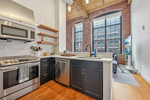 a kitchen with stainless steel appliances and a large window at Riverwalk Apartments, Lawrence, MA