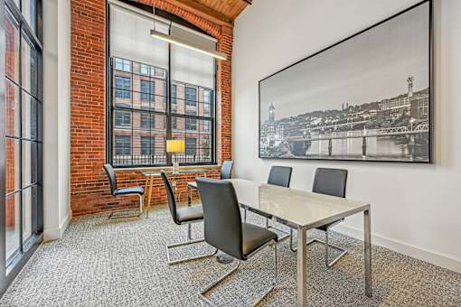 a conference room with a table and chairs and a large window at Riverwalk Apartments, Lawrence, MA