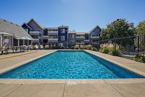 A large swimming pool in front of a building. at Windmill Apartments, Colorado Springs, 80916