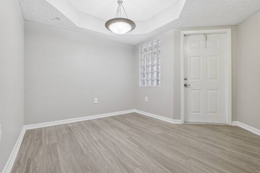 an empty living room with a white door and wood flooring at Pembroke Pines Landings, Pembroke Pines