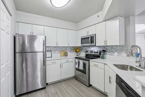 a kitchen with white cabinets and stainless steel appliances at Pembroke Pines Landings, Pembroke Pines, Florida