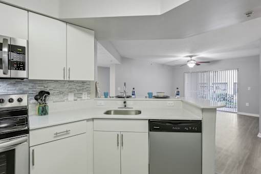 a kitchen with white cabinets and a sink and a stove at Pembroke Pines Landings, Florida