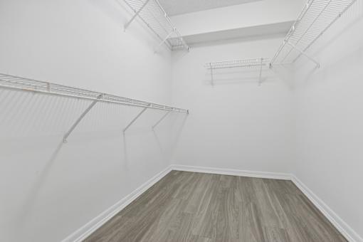 a room with white walls and wood floors and a white closet at Pembroke Pines Landings, Pembroke Pines, Florida