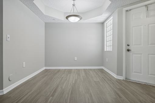 an empty living room with a white door and wood flooring at Pembroke Pines Landings, Florida, 33025