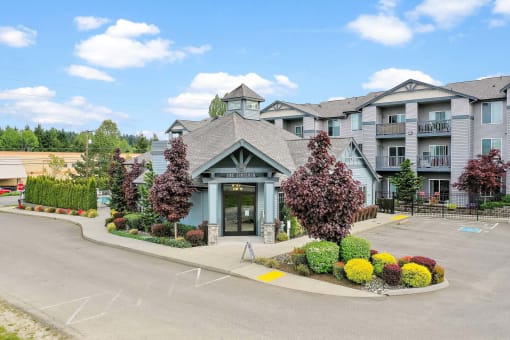 the front of a building with a parking lot and landscaping