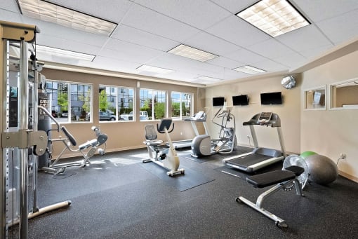 a gym with exercise equipment and windows