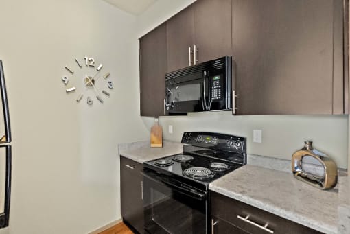 a kitchen with stainless steel appliances and a clock on the wall