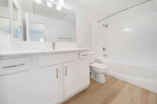 A white bathroom with a toilet, sink, and bathtub.