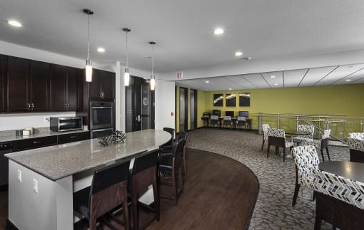 a business area with two desks and computers and a kitchenette area with high-top seating