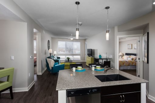 an open apartment layout with a sink, dishwasher, living space, and large windows