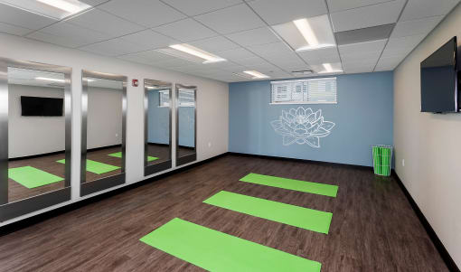 a yoga studio with large mirrors and yoga mats