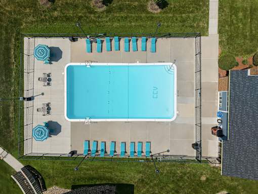 An aerial view of a swimming pool with lounge chairs and umbrellas.