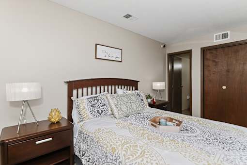 A bedroom with a bed, nightstand, and lamp.