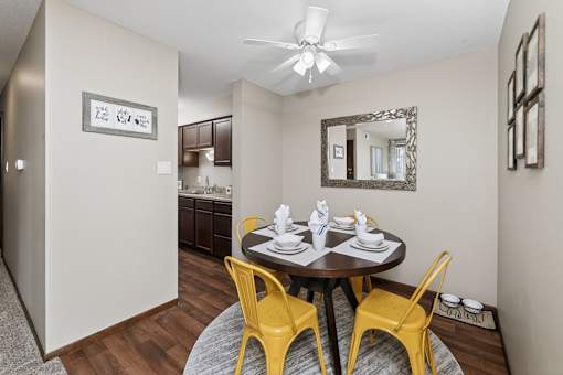 A dining room with a round table and yellow chairs.