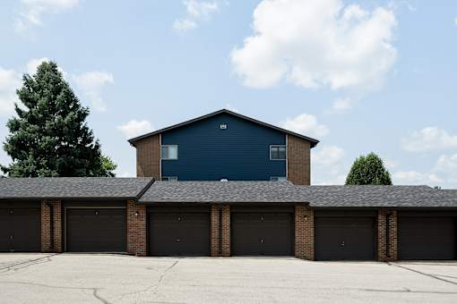 A blue building with a black roof and a garage door.