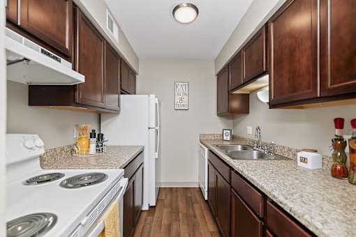 A kitchen with brown cabinets and a white stove top oven.