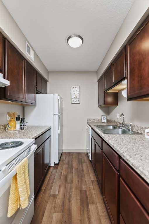 A kitchen with a white fridge and wooden cabinets.