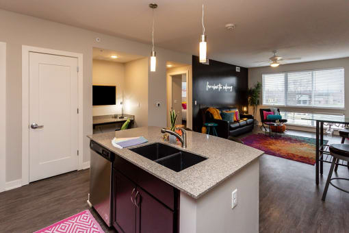 an open kitchen and living room with a large window and a sink