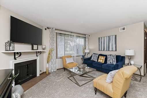 A living room with a fireplace, a blue couch, and a television.
