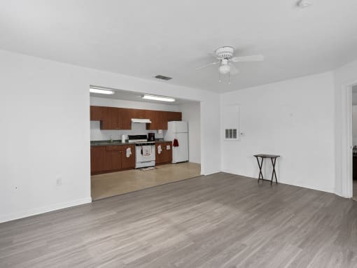 living room with a ceiling fan and a kitchen at The Groves at Wimauma Apartments , Wimauma, 33598