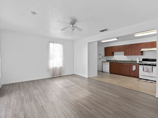 an empty living room and kitchen with a ceiling fan at The Groves at Wimauma Apartments , Wimauma, FL