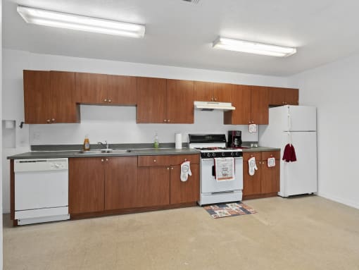a kitchen with white appliances and wooden cabinets and a white stove and refrigerator at The Groves at Wimauma Apartments , Wimauma, Florida