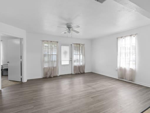the living room of an empty house with a ceiling fan at The Groves at Wimauma Apartments , Wimauma