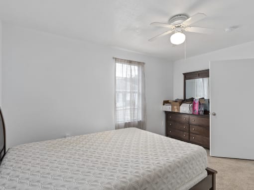 an empty bedroom with a bed and a ceiling fan at The Groves at Wimauma Apartments , Wimauma, FL, 33598