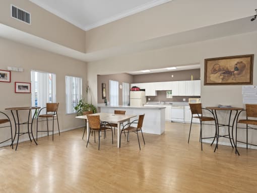 a dining room with a table and chairs and a kitchen at The Groves at Wimauma Apartments , Florida 33598