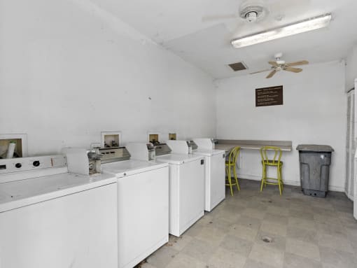an empty room with white appliances and a yellow chair at The Groves at Wimauma Apartments , Wimauma, FL, 33598