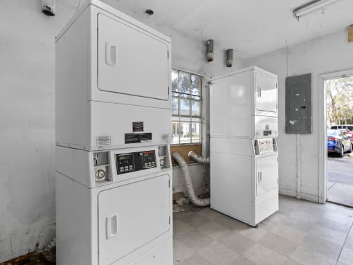 two white refrigerators in a white room with a window at The Groves at Wimauma Apartments , Florida