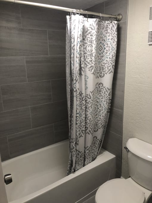 a bathroom with a toilet and a bathtub at Colonial Apartments, Orlando, 32808