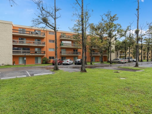 the view of an apartment building with cars parked in a parking lot at Cypress Grove, Lauderhill, 33313