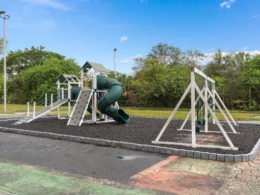 a playground with a swing set and a slide at Cypress Grove, Lauderhill, FL, 33313