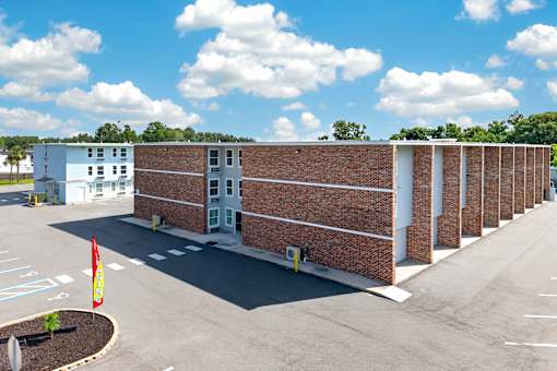 A parking lot with a building and a flag.
