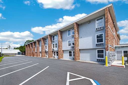 A parking lot in front of a multi-story brick building.
