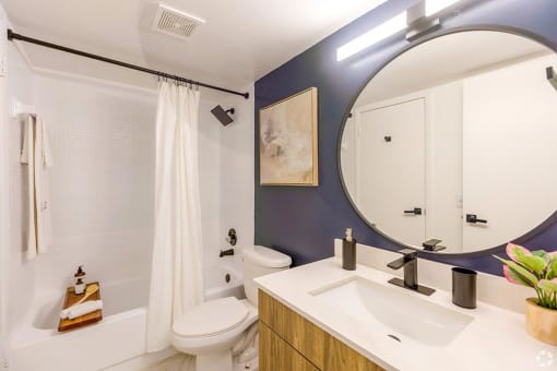 a bathroom with blue walls and a white shower curtain  at Club at Emerald Waters, Hollywood, FL, 33021