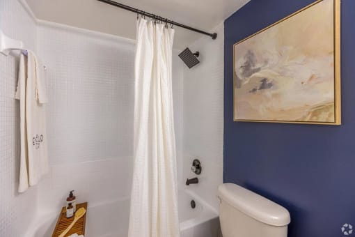 a bathroom with blue walls and a white shower curtain  at Club at Emerald Waters, Florida