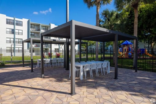 a covered patio with tables and chairs  at Club at Emerald Waters, Hollywood, FL, 33021