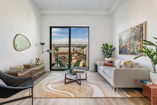 A living room with a view of the city through a large window at WM by CLG, California  