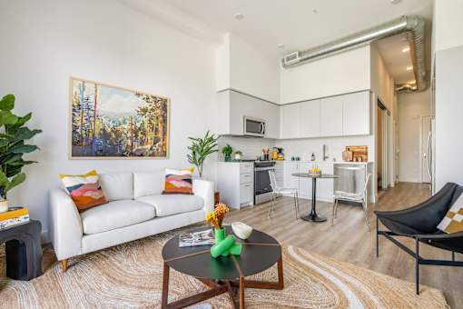A living room with a white couch, a coffee table, and a painting on the wall at WM by CLG, Los Angeles, CA  