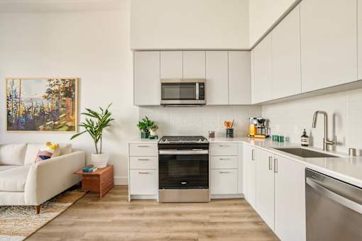 A modern kitchen with white cabinets and a stainless steel oven at WM by CLG, Los Angeles, 90232  