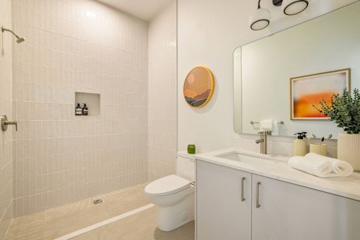 A bathroom with a white toilet and a white sink at WM by CLG, Los Angeles, CA 90232  