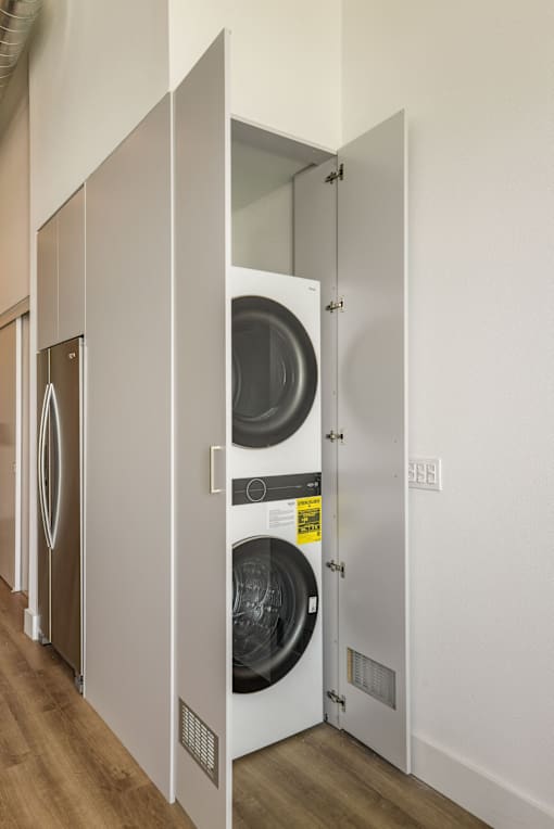 A row of white washing machines in a laundry room at WM by CLG, Los Angeles, CA  