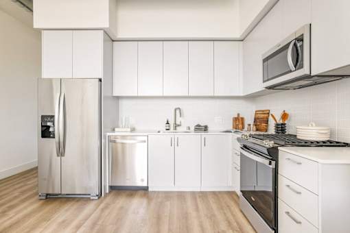 A modern kitchen with white cabinets and stainless steel appliances at WM by CLG, Los Angeles, CA 90232  