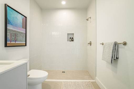 A white bathroom with a toilet, sink, and shower at WM by CLG, California, 90232