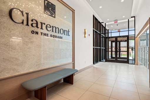 A hallway with a bench and a sign that says Claremont on the square.