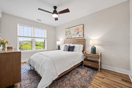 A bedroom with a large bed and a ceiling fan.