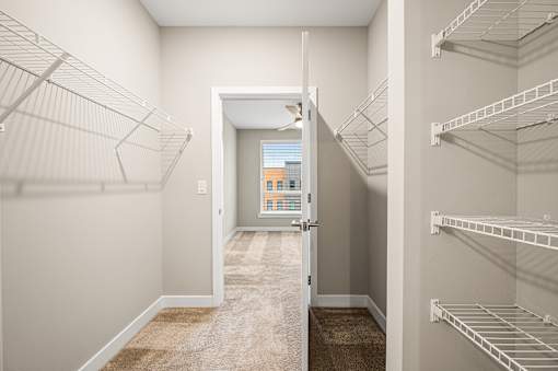 A hallway with a doorway leading to a balcony.