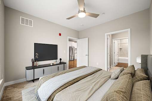 A bedroom with a large bed and a flat screen TV.